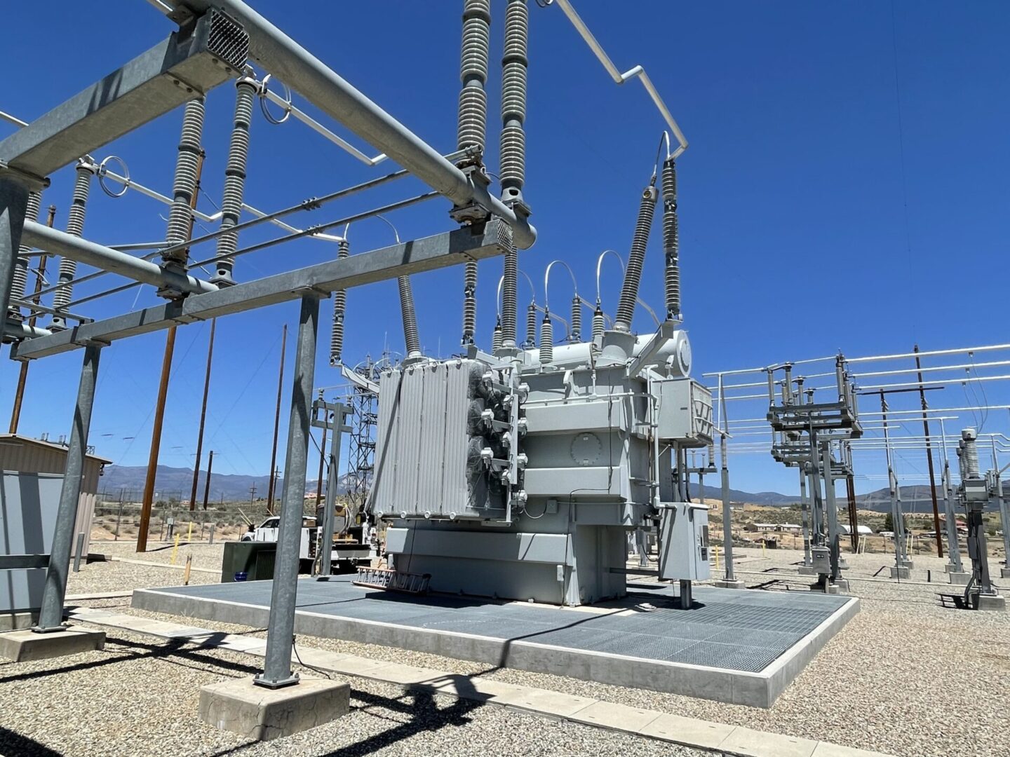 A large electrical transformer sitting on top of concrete.